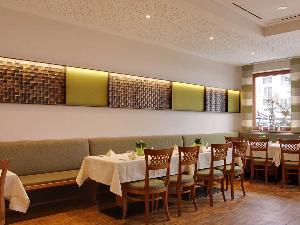Eines der Restaurants im Altmühltal ist in grünem Design mit Sitzbänken und Stühleln ausgestattet und bietet viel Platz für viele Gäste