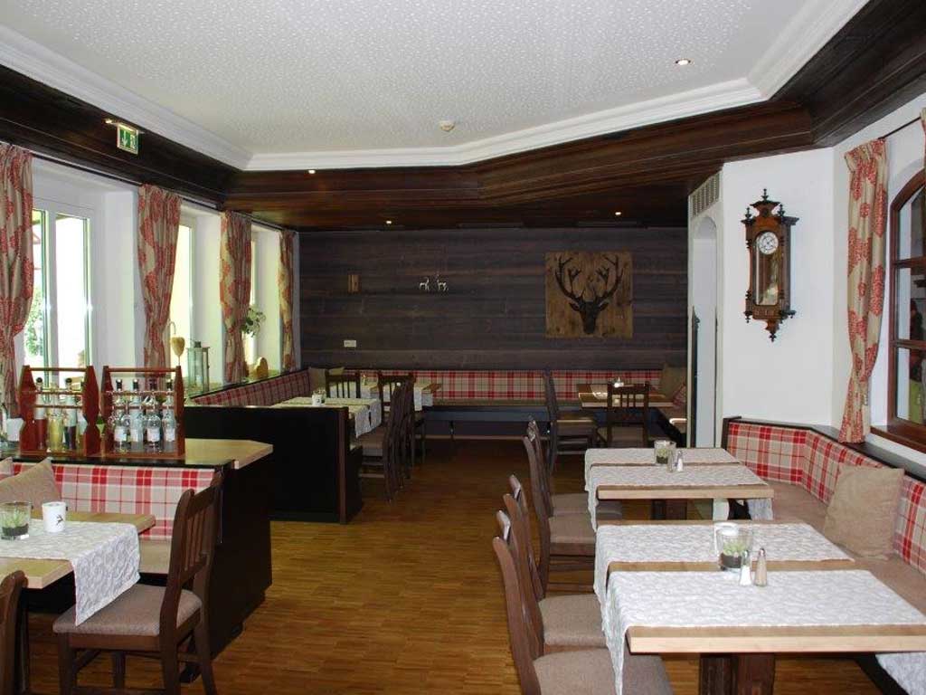 Ein traditionell eingerichtetes Restaurant aus dem Altmühltal mit dunklen Holztischen und -stühlen, einer alten Uhr und einem Holzbild 