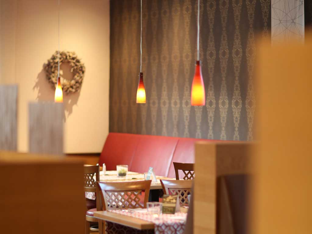 Eines der Restaurants im Altmühltal ist im roten orientalischen Design mit gold-schwarzen Tapeten, hängenden Lampepn und roten Lederbänken