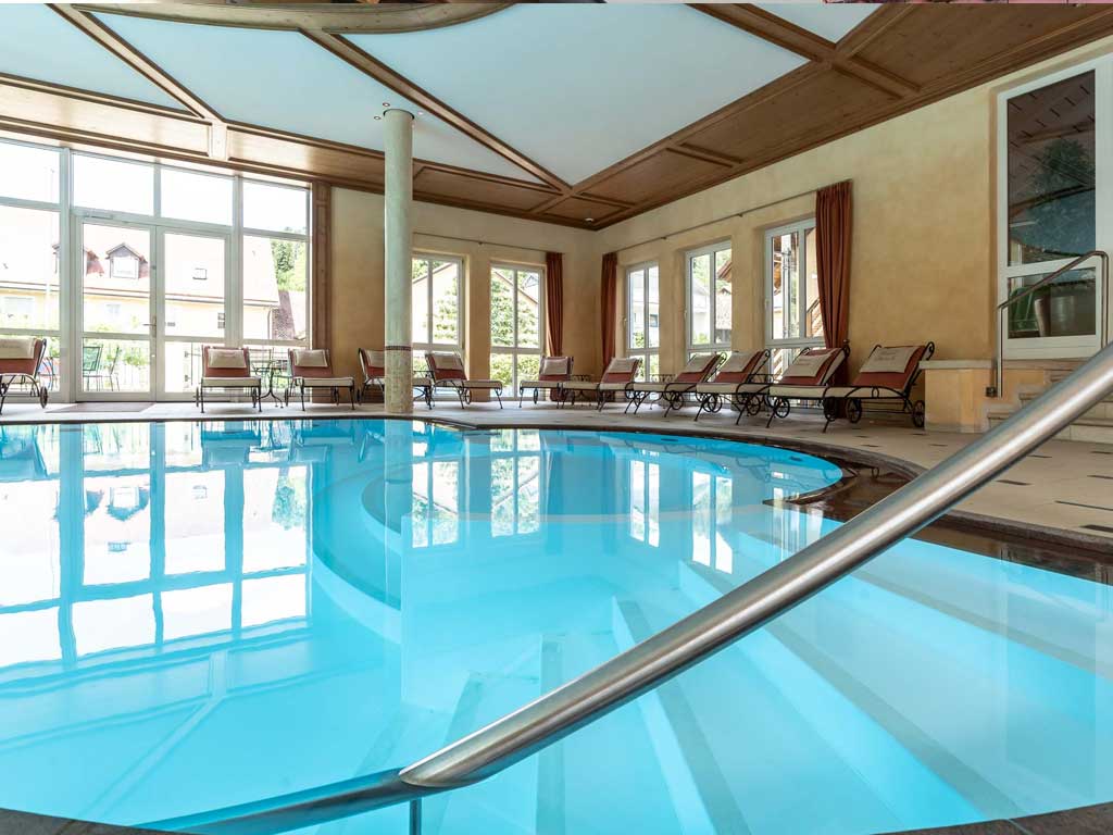 Das große Schwimmbad des Wellnesshotels im Altmühltal mit Liegeplätzen und Wohlfühlatmosphäre 