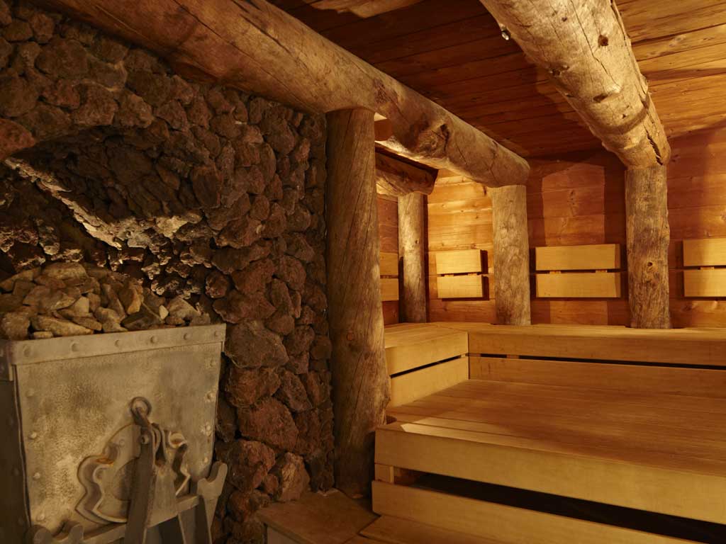 Die Kelosauna im Wellnesshotel des Altmühltals ist umgeben von Holzstämmen und steinernden Wänden