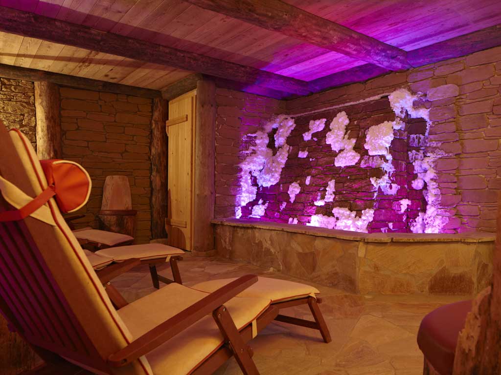 Der Salz-Sole-Stollen bietet einen Rückzugsort im Wellnesshotel im Altmühltal mit seinen Liegestühlen, Mauerwänden und violettem Dämmerlicht