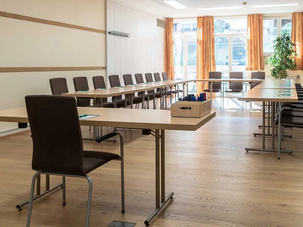 Der Meetingraum des 4* Tagungshotels im Altmühltal hat große Fenster, die viel Licht reinlassen und lange Tische zum erfolgreichen Tagen