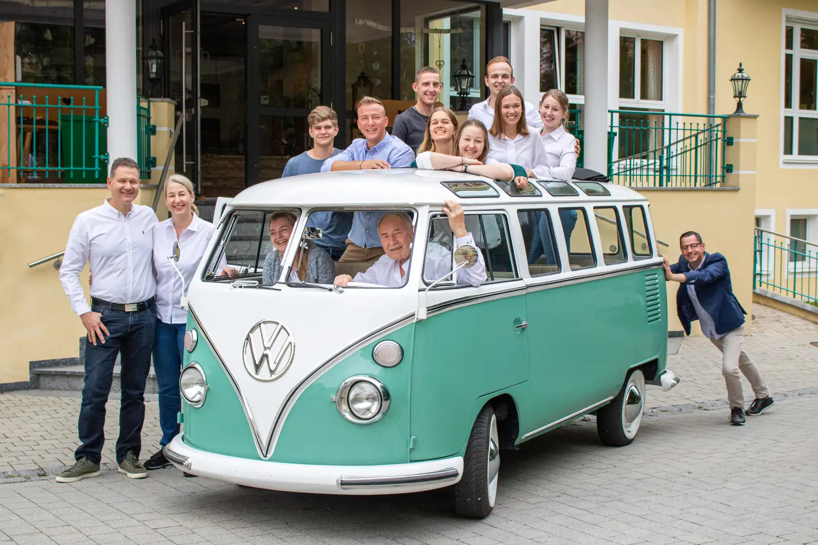 Familie und Team des Hotel Dirsch gemeinsam am historischen VW-Bulli